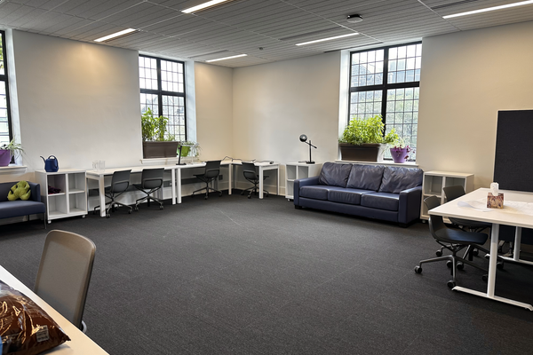 A large open room with desks and chairs at the edges