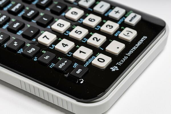 Close up of a black calculator with white keys