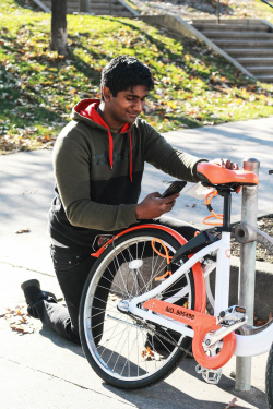Man using his smartphone to engage a Dropbike.