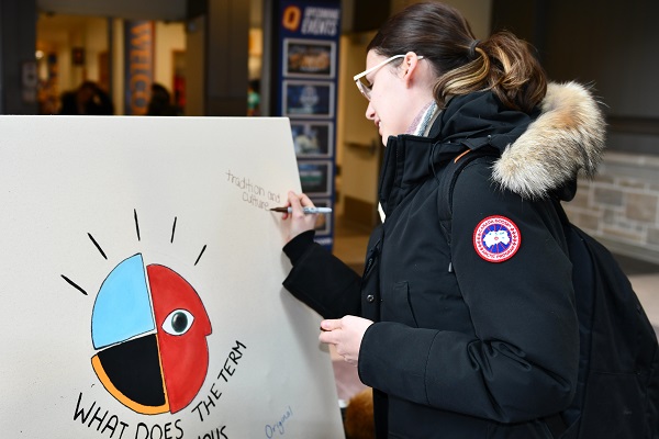 A student contributes to the Indigenous Awareness Week whiteboard. (University Communications)
