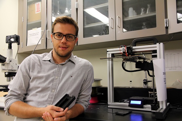 Matthias Hermann (MSc’17) poses with his invention – a device which detects cadmium in drinking water. (University Communications)
