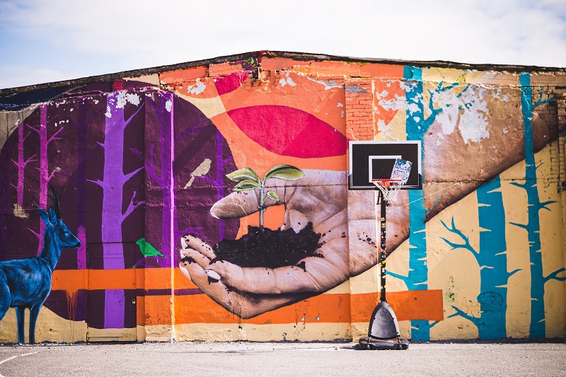 Mural shows a hand holding a small plant