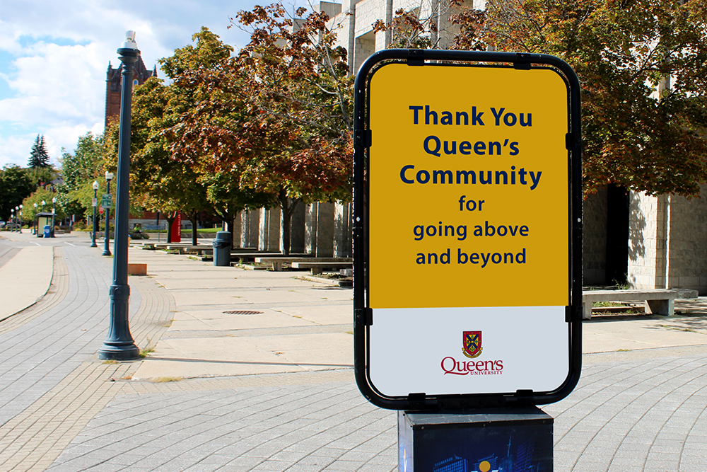 On-campus sidewalk signage thanking the Queen's community for going above and beyond.