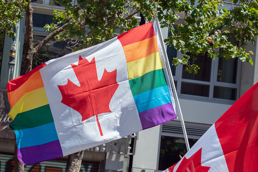 [Photograph of Pride flag and Canadian flag]