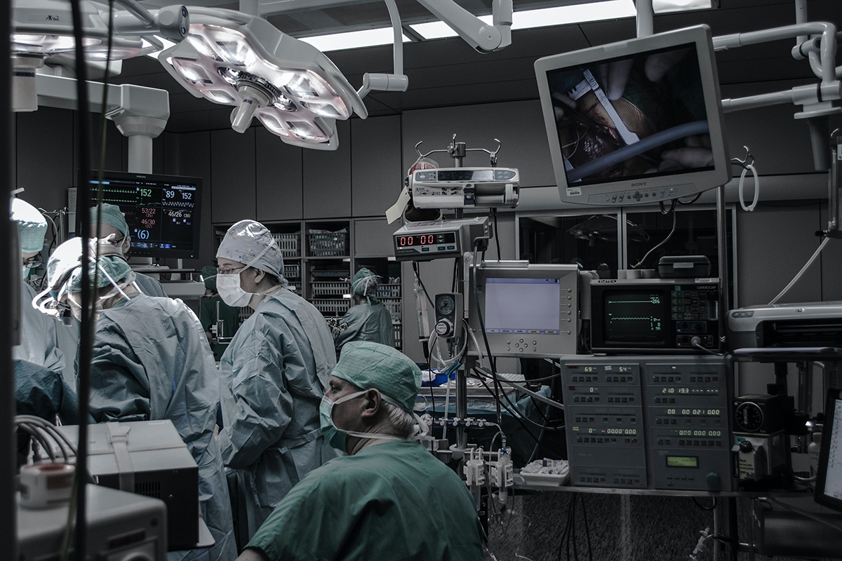 A medical team performs surgery on a patient. 