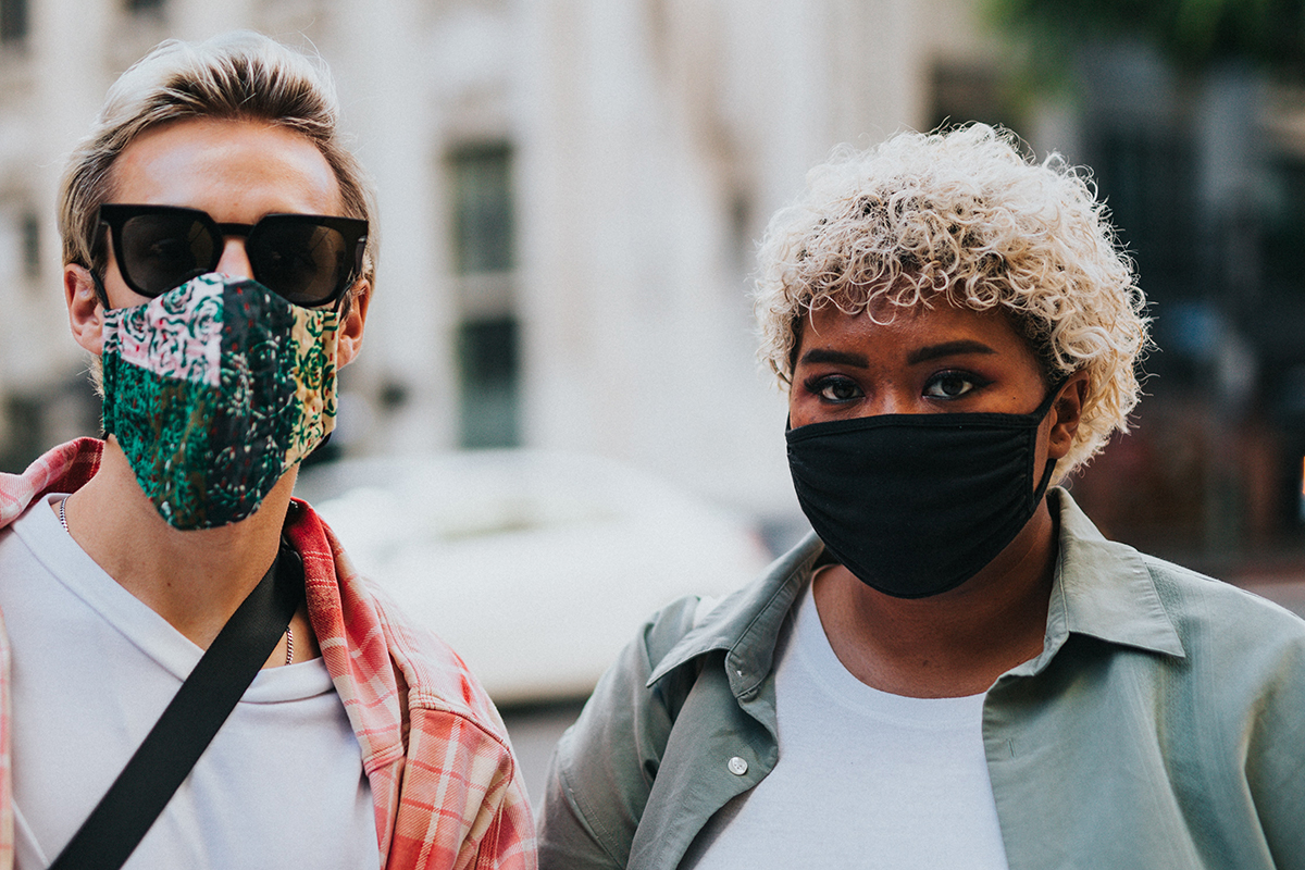 A couple wear facemasks and glasses
