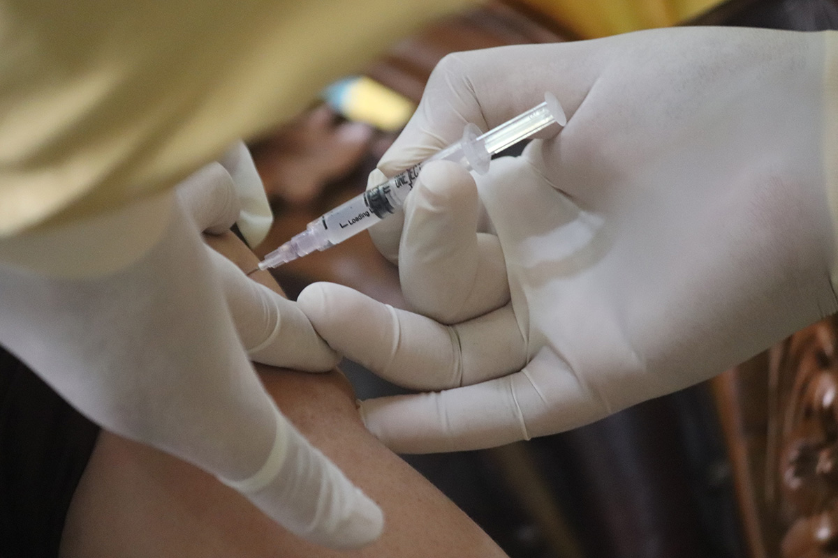 A person is injected with a COVID-19 vaccine in their arm