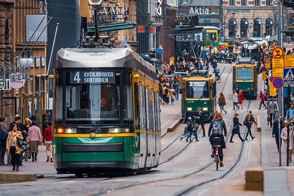 A streetcar climbs a street in heavy traffic