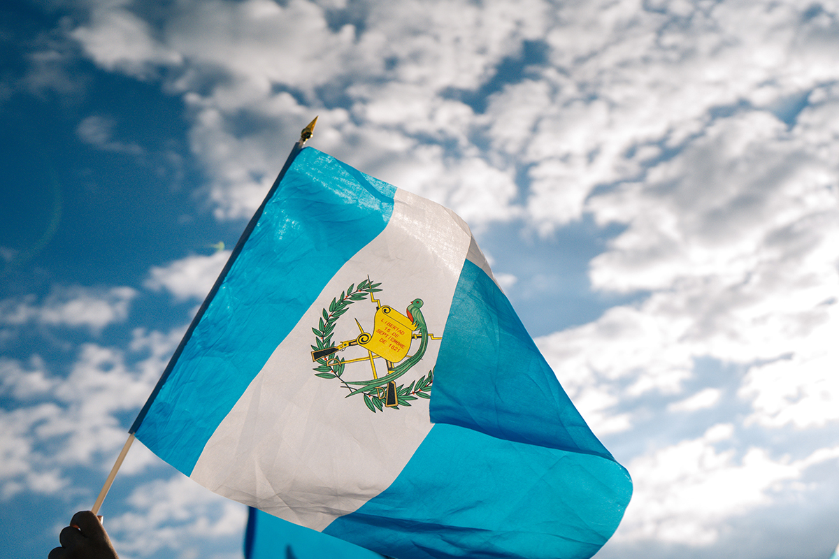 A person hold the flag of Guatemala
