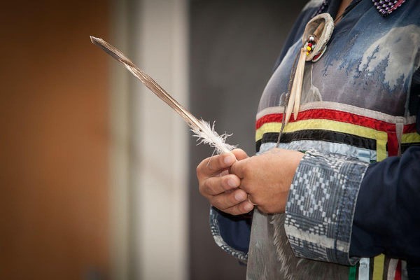 Photograph of a person holding a feather