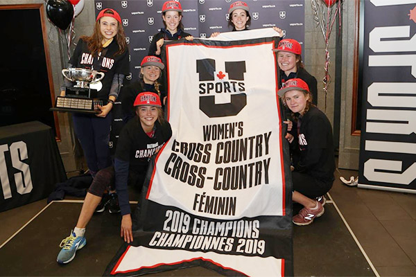 [Gaels hold up the USPORTS women's cross country banner]