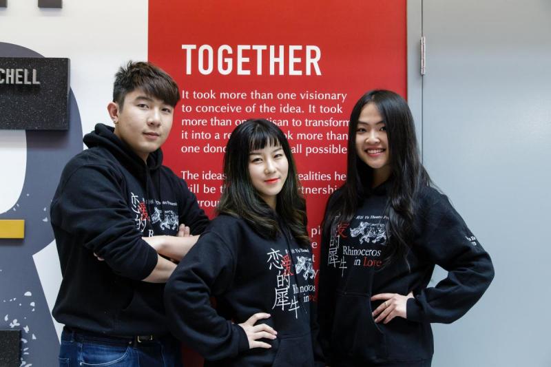 [photo of three students near the 'Together' sign in Mitchell hall]