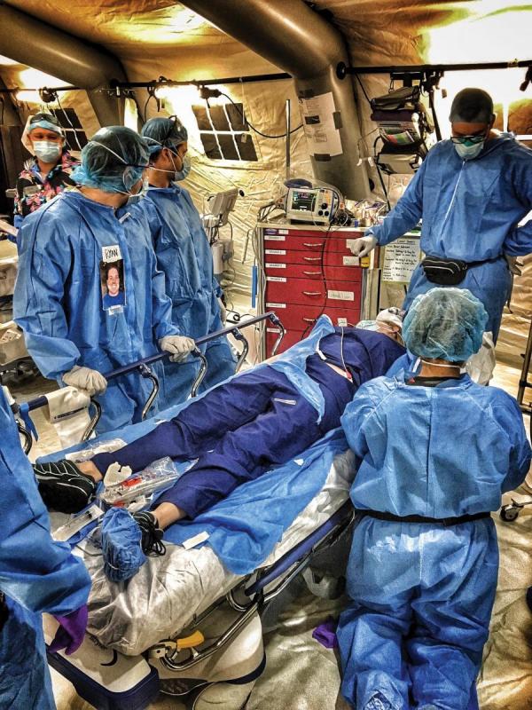 [photo of medics practising procedures on a test patient]