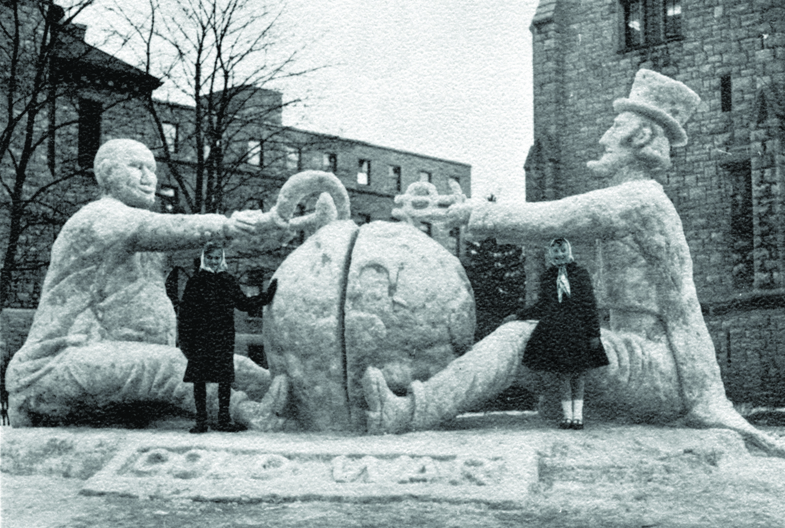[1961 photo of a campus snow sculpture entitled "Cold War" featuring Uncle Sam and Khrushchev fighting over a globe]