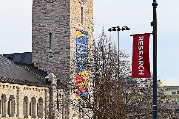 [Photo of Grant Hall featuring a "Research" pole pennant]