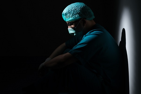 Health care worker sits in the dark