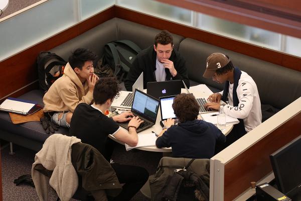 A group of students gather around a desk in Stauffer Library.