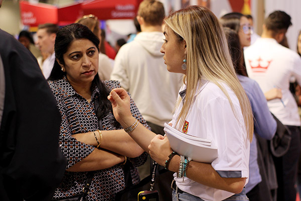 A Queen's student representative speaking with a family at a previous Ontario Universities' Fair.