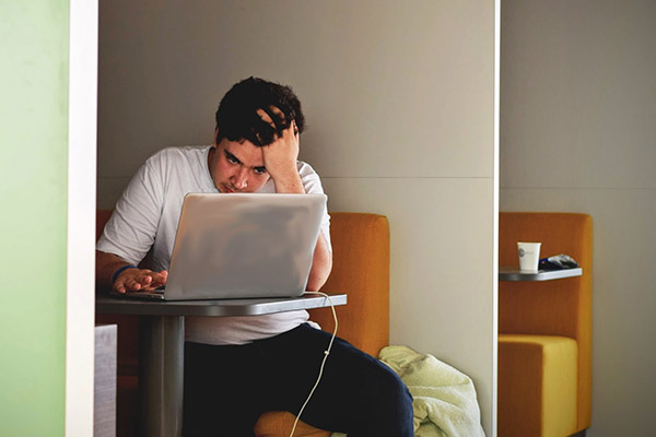 photo of stressed student with computer