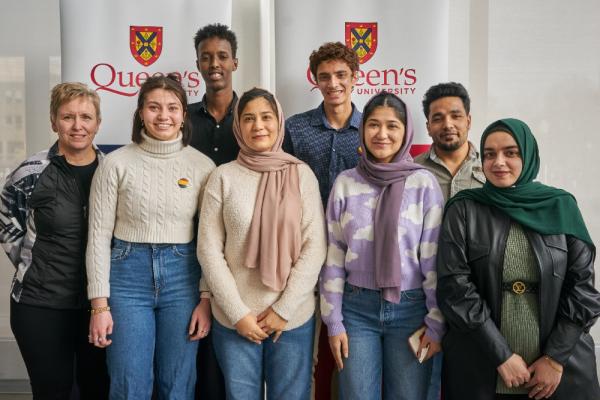 Photograph of students in the Queen's-WUSC Local Committee with students in the WUSC Student Refugee Program and Teresa Alm, who supported the program as Associate Registrar