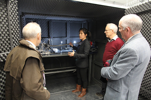 Research Associate Bei Cai explains one of the experiments currently being conducted at the physics lab of Gilles Gerbier, second from right, to Council of Ontario Universities President David Lindsay, right, and Provost Alan Harrison.