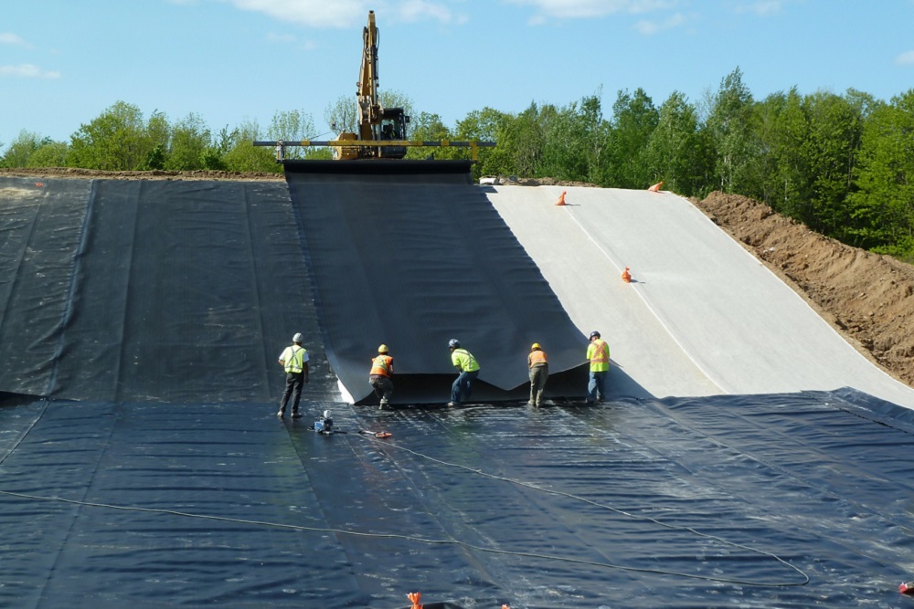 [Photo of Dr. Rowe's team working on installing a liner at the Queen's University Environmental Liner Test Site in Godfrey, Ontario]