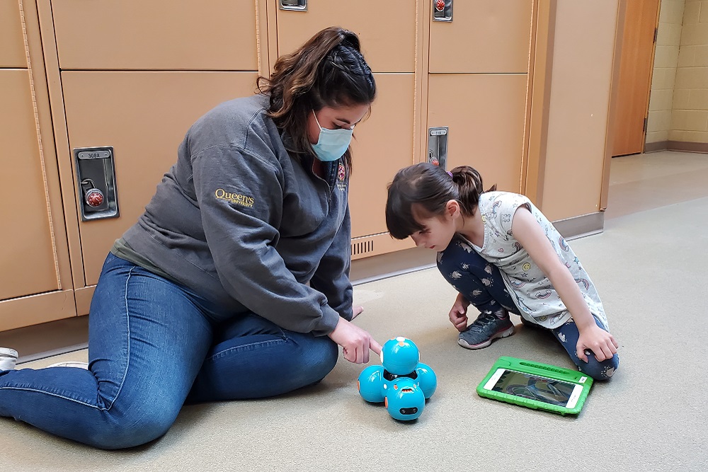 [Nicole General, Indigenous STEM Outreach Coordinator with InEng, works with a young student.]