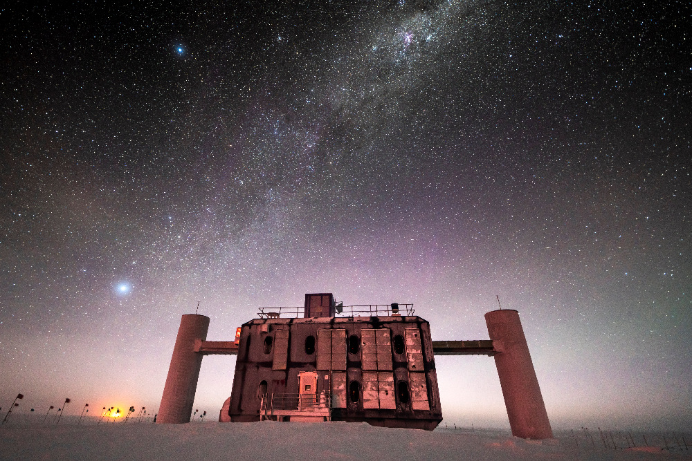 Credit: Martin Wolf, IceCube/NSF – Front view of the IceCube Lab at twilight, with a starry sky showing a glimpse of the Milky Way overhead and sunlight lingering on the horizon. 