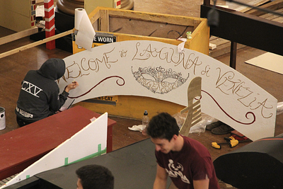 An engineering student works on the lettering of sign for the 2018 Science Formal, “Welcome to Laguna di Venezia”. (University Communications)