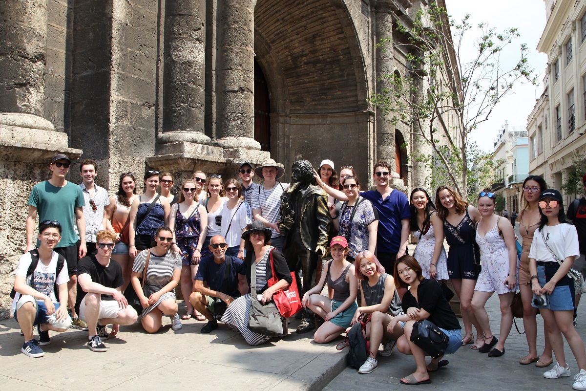 [The 2018 Cuba trip cohort pose together with a statue in Havana. (Photo: Chris Tianyu Yao)]