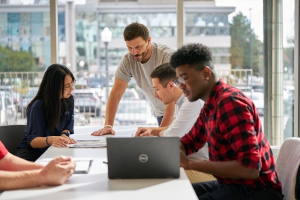 A group of employees work at a desk during a workshop