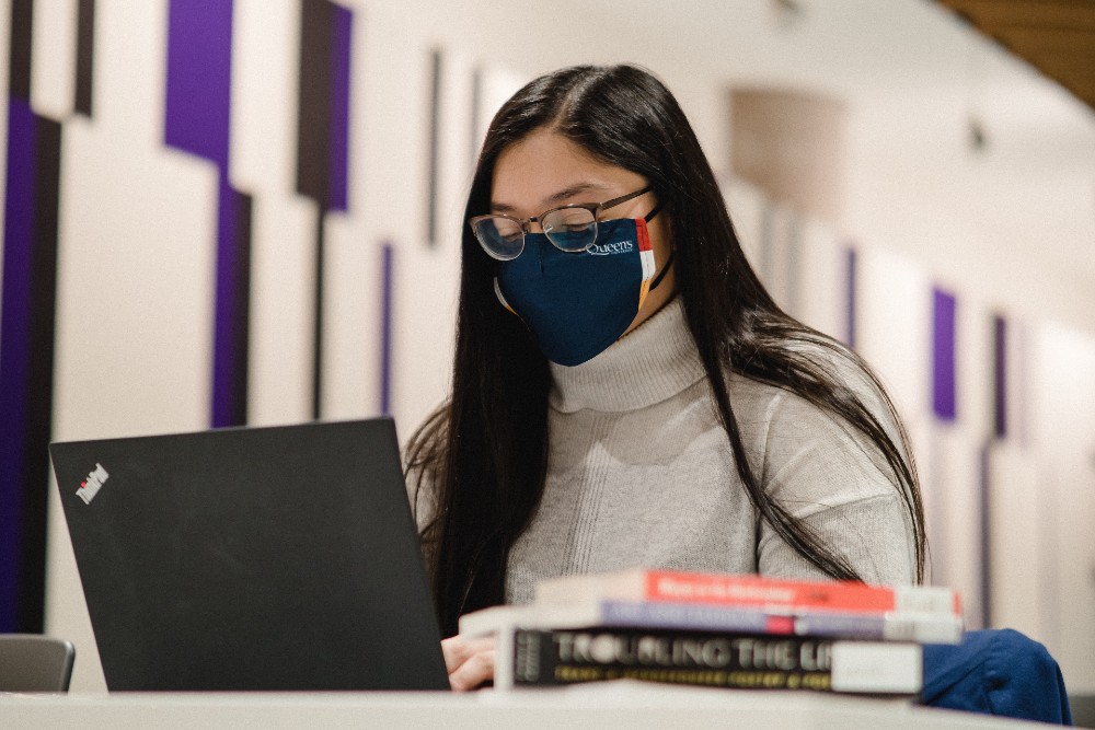 Photograph of a student working on a laptop computer.