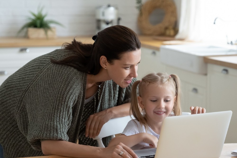 Photo of woman and child using a laptop