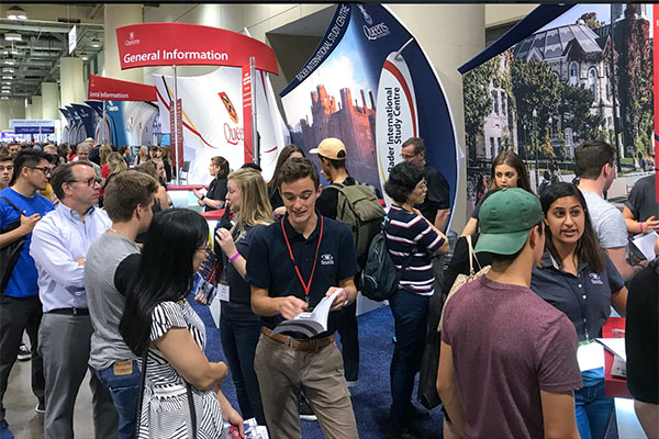 "Queen's University booth is busy at the annual Ontario Universities Fair in Toronto" 