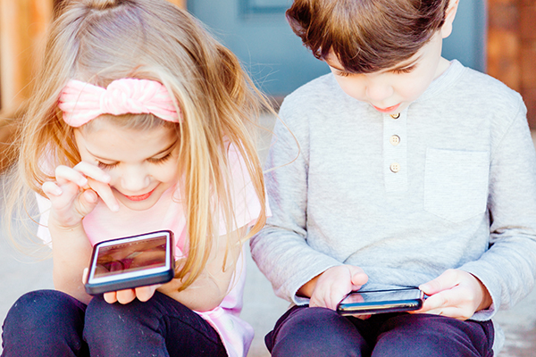 Two children use cellphones