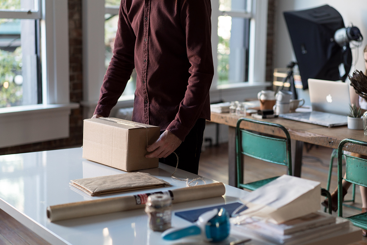 Employee wrapping a package at his desk.