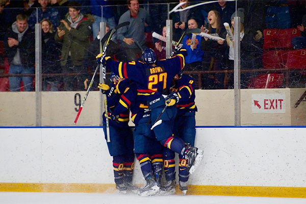 [Queen's Gaels men's hockey players celebrate a goal]