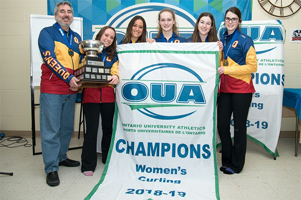 {Queen's Gaels women's curling team pose with the OUA banner and trophy]