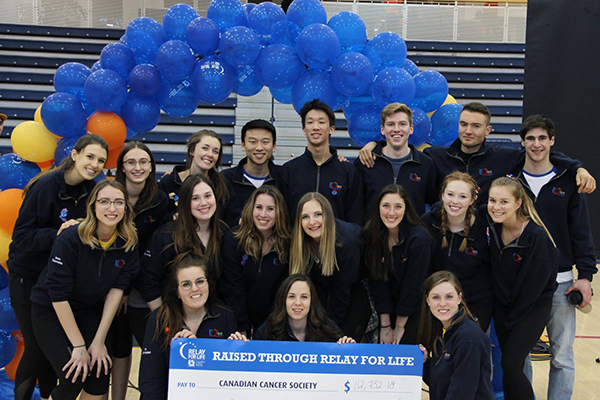 By Andrew Carroll, Gazette editor For the majority of Queen’s Relay for Life participants, getting involved in the annual fundraiser for the Canadian Cancer Society is personal. And that’s the case for the three co-presidents of this year’s event. For Josh Barnes (Artsci’19) his grandmother and aunt battled the disease and survived. Danica Goodchild (Artsci’18) met a cancer survivor and fellow student at her high school and the two have become close friends through Relay. Madison Yakimishyn (NSc’19) lost her mother when she was just nine years old. Each year, Queen’s students gather at the Athletics and Recreation Centre to participate in a 12-hour overnight relay to raise funds for the battle against cancer. This year, the 12th annual event, being held Friday, March 9 and Saturday, March 10, is aiming to attract 500 participants and raise $115,000. A mixture of fun, determination and remembrance, the strength of the Relay for Life is the sense of community it creates and the support it provides to survivors, those battling cancer, and for those who have lost loved ones. “One of the things that is so special about Relay is that you have those moments where you are celebrating the people who have survived but you also have those really profound moments that are really reflective and allow people to come together through those they have lost,” says Ms.Yakimishyn.  Planning for the Relay started in the summer and ramped up during the fall semester. Working with an organizing committee of 24 students from across campus, the co-presidents say that it has been a lot of work but it definitely has been rewarding. Throughout the night participants will be able to take part in team challenges and fun activities, while the signature Luminary Ceremony – where candles are lit for loved ones lost – will be held at midnight. They will also hear from survivors about what the Relay for Life really means and why the battle must continue. “Hopefully the more years we run the Relay for Life the more success stories we will have,” Mr. Barnes says. “That’s what we are working towards.” To learn more or to get involved, visit the Queen’s Relay for Life website of Facebook page