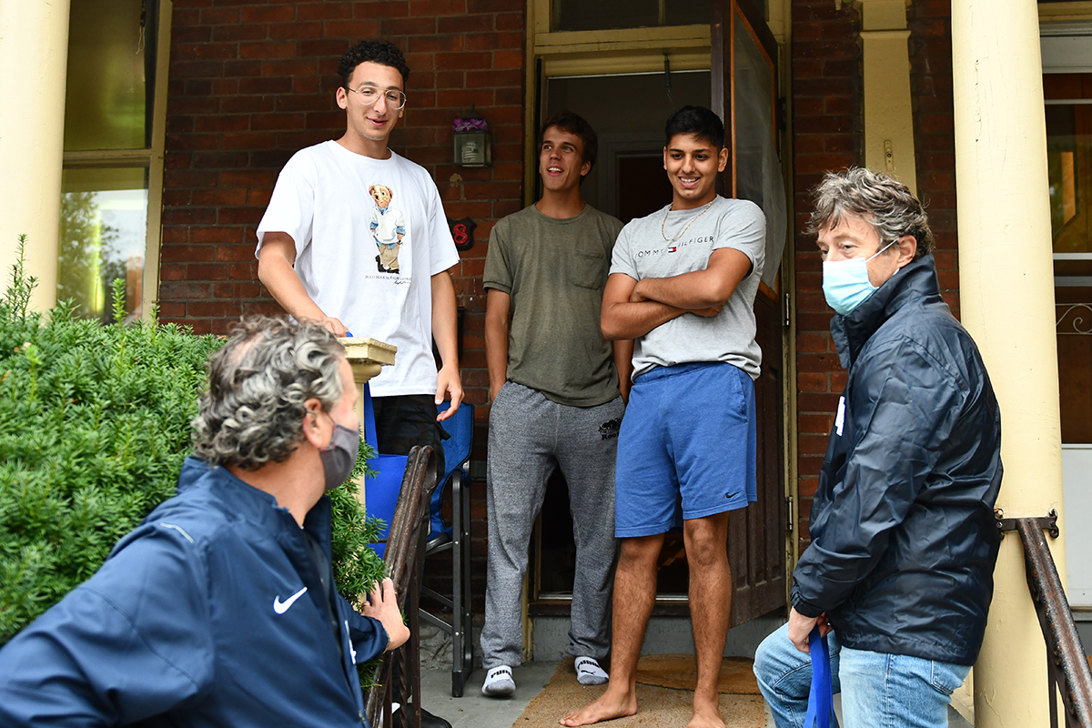 Queen's senior leadership team members welcome Queen's students in the University District