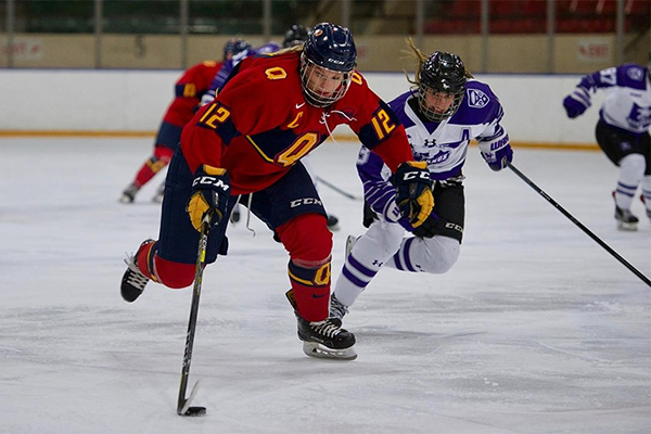 [Queen's Gaels women's hockey captain Addi Halladay moves the puck]