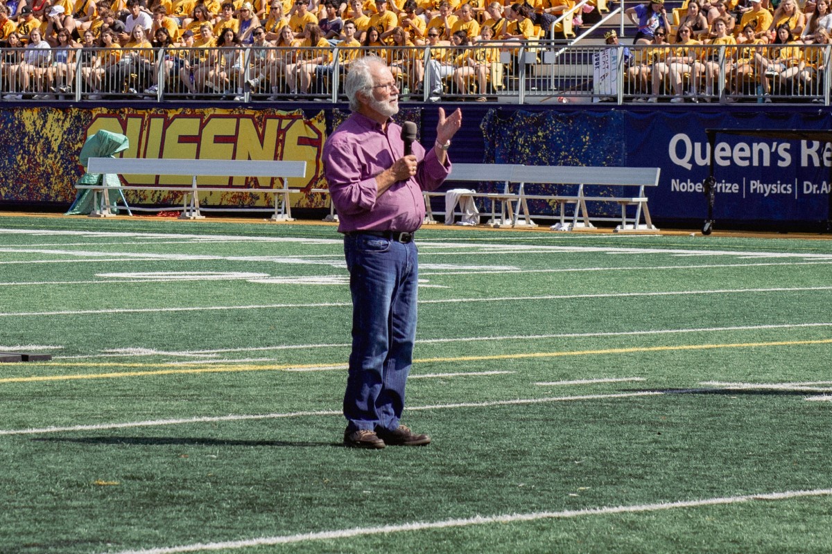 Photograph of Queen's Principal Patrick Deane addressing first-year students during orientation.
