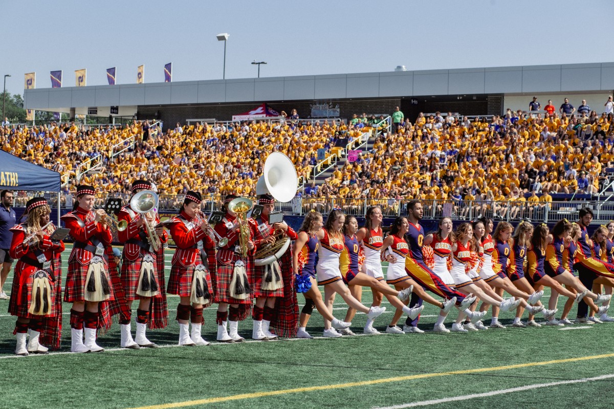 Photograph of Queen's Bands and Cheerleaders teaching the Oil Thigh to first-year students during orientation.