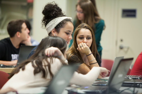 [Students working on laptops]