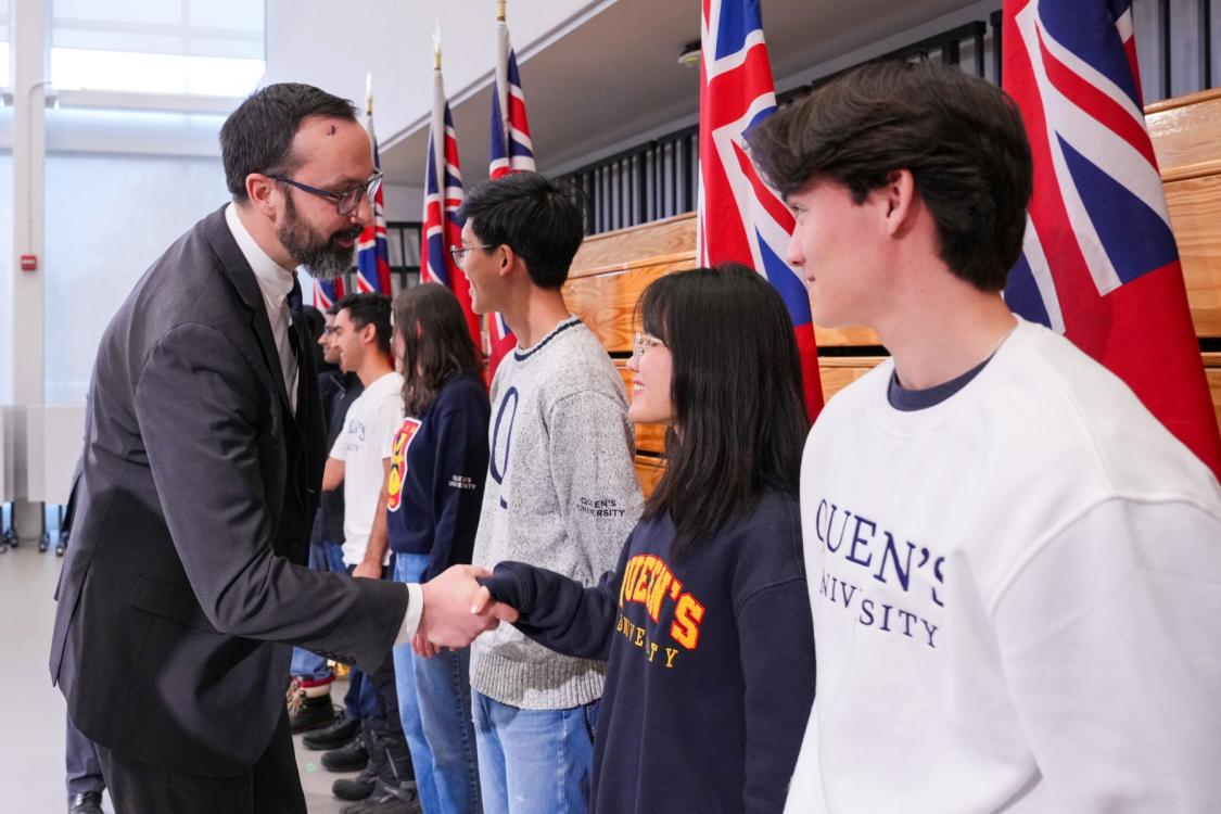 Minister Quinn shakes hands with Queen's students