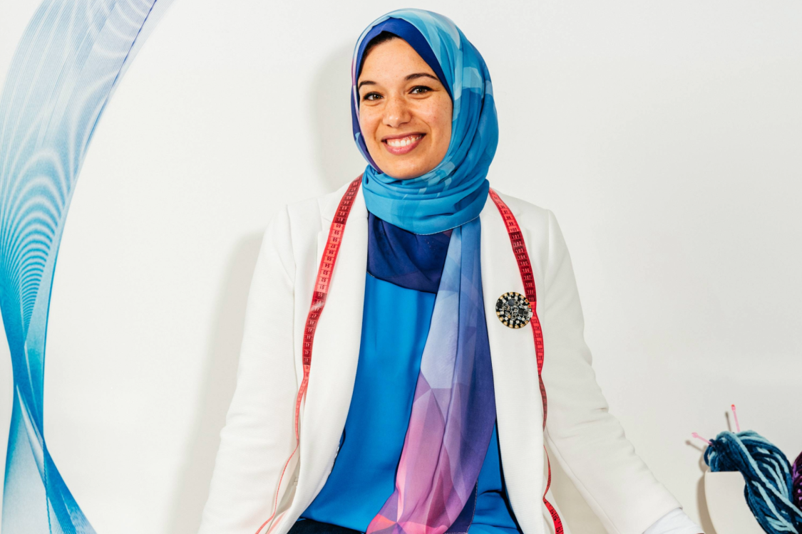 Photo of Dr. Sara Nabil with some yarn standing against a white wall