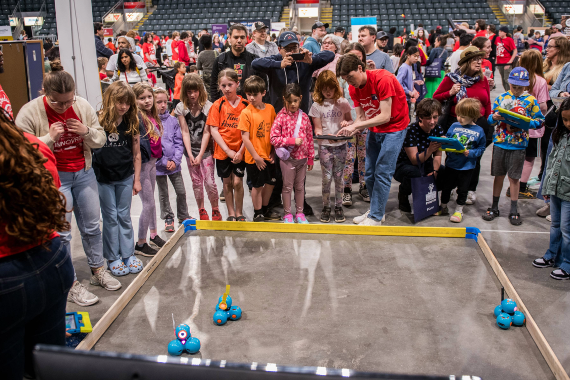 Group of kids around small robots