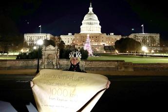 Raphael Fenski holds up a sign in front of the Capitol Building in Washington, D.C.