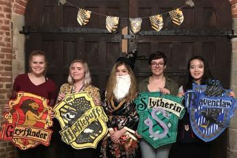 'Dumbledore' and a few 'Hogwarts' students hold up the four Harry Potter house crests. (Supplied Photo)
