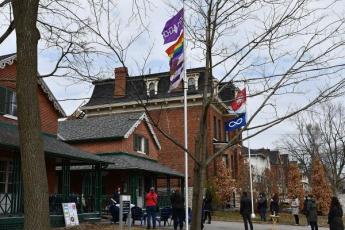 The two flag poles in front of Four Directions Indigenous Student Centre now fly six flags